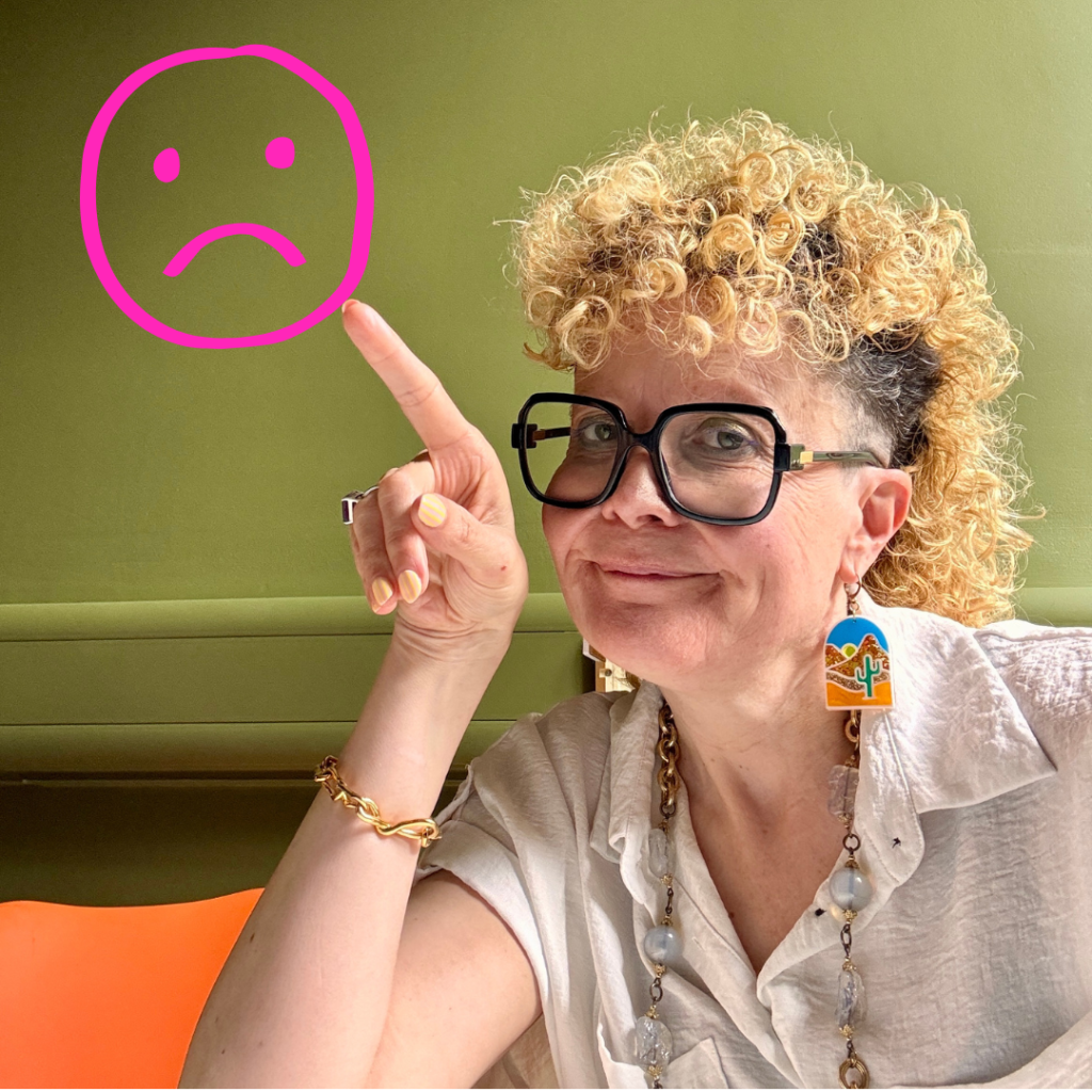 Lucy pointing at a sad smiley face
